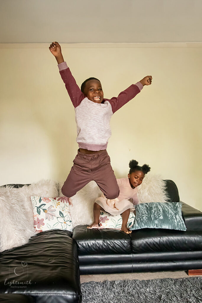 a boy doing a massive jump off the sofa