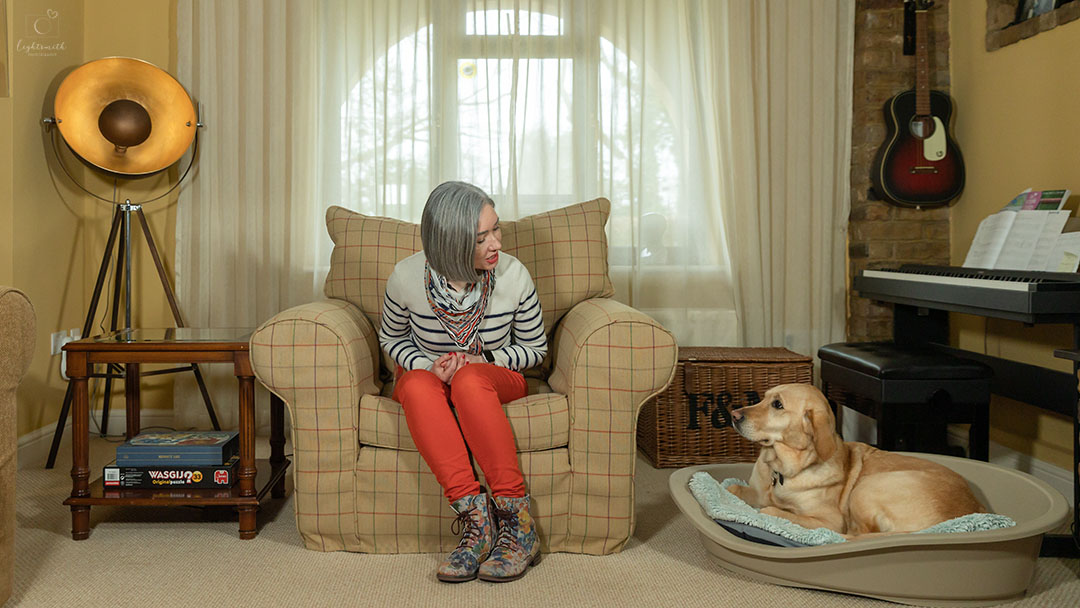 a woman sitting in her sitting room looking at her dog