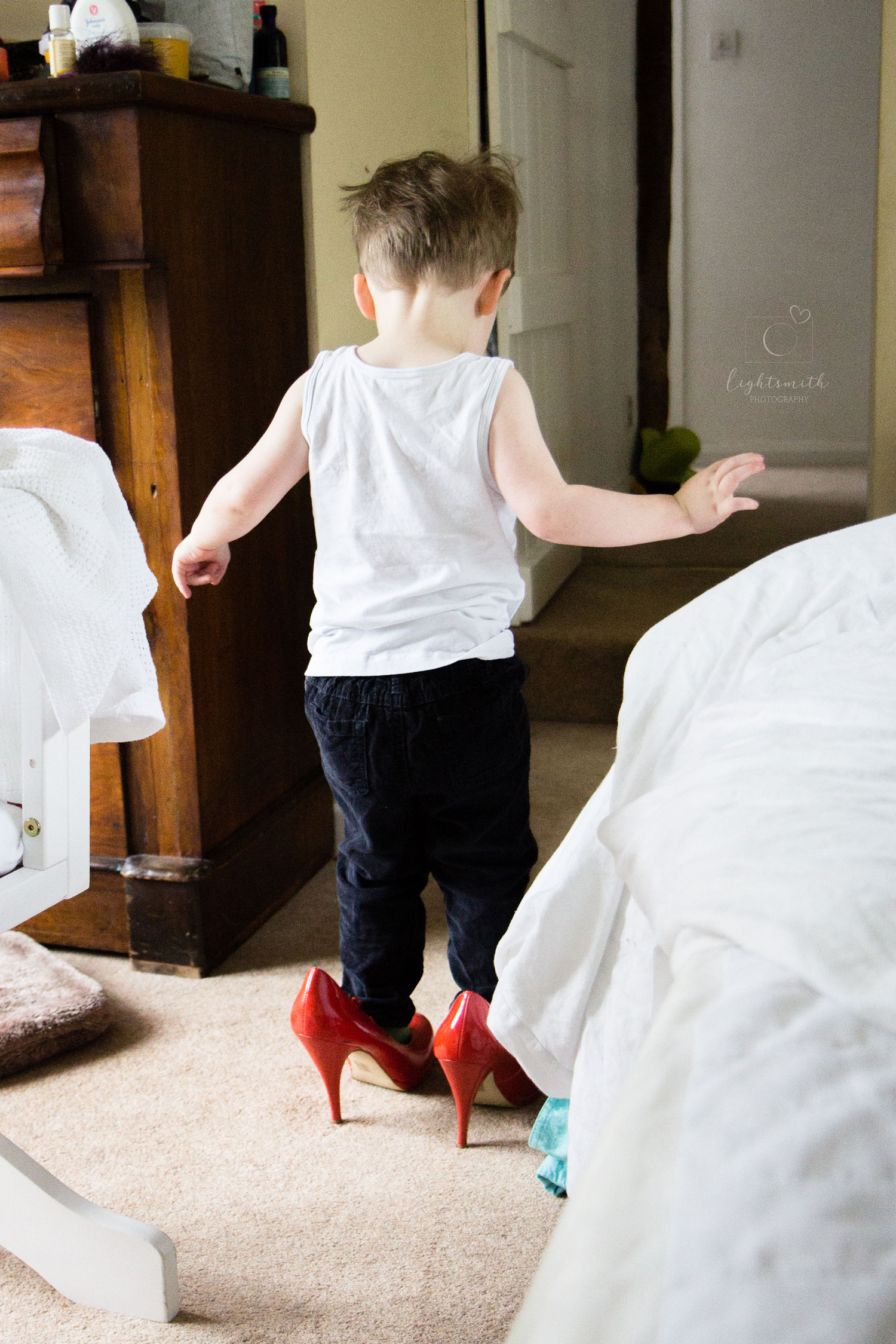 a toddler walking in orange high heels